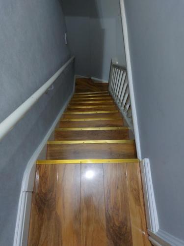 an empty hallway with a wooden floor and stairs at Hanwell House in Liverpool