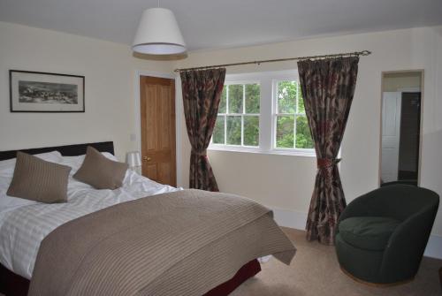 a bedroom with a bed and a chair and a window at Church house in Claines