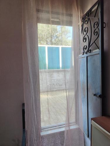 een raam met witte gordijnen in een kamer bij Al Piccolo Alloggio in San Carlo