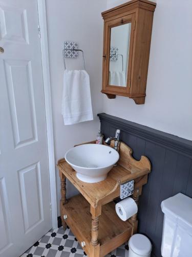 a bathroom with a sink and a toilet and a mirror at Character Beverley Town House in Beverley