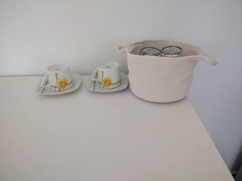 two tea cups and a basket on a table at Bay-dream 1 in Adamas