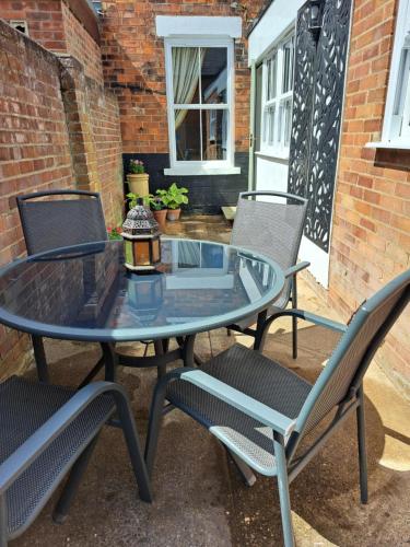 a glass table and chairs on a patio at Character Beverley Town House in Beverley