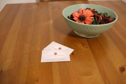 a flower in a bowl on a table with a card at Le Dimore degli Artisti in Venosa