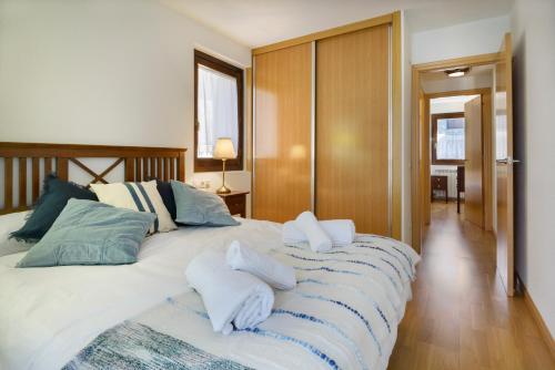 1 dormitorio con 1 cama grande y toallas. en Alojamiento Villanua Pirineos, en Villanúa