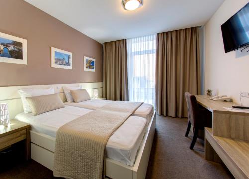 a hotel room with a bed and a desk at Hotel Argentum in Mostar