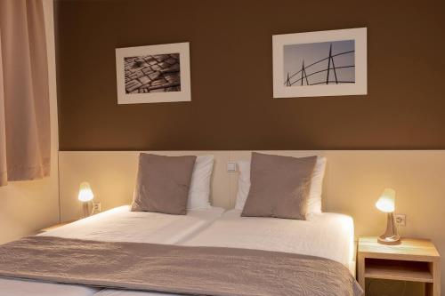 a bedroom with a bed with two lamps on it at Hotel Argentum in Mostar