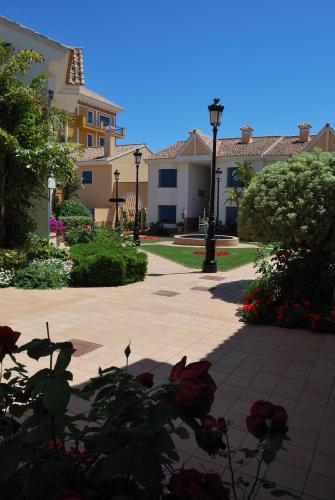 a walkway in front of a house with flowers at Hotel Golf Campoamor in Dehesa de Campoamor