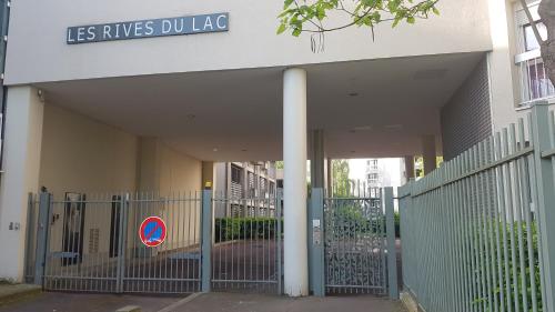a gate in front of a building with a sign on it at une chambre privee entre paris et disneyland in Noisy-le-Grand