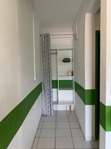 un pasillo con paredes verdes y blancas y una cortina en Tranquillité Vert en Pointe-Noire