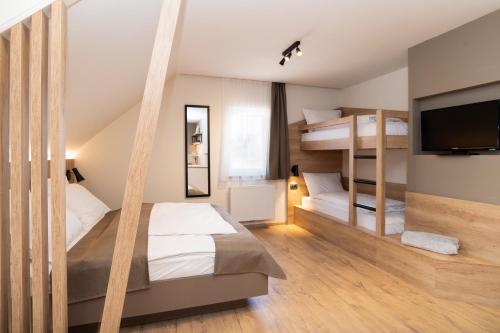 a bedroom with two bunk beds and a flat screen tv at Penzion Repanšek in Radomlje