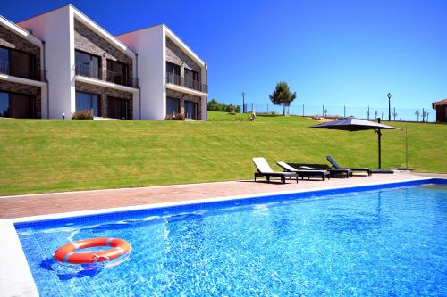 a swimming pool with a red lifebuoy in front of a building at Monte Bela Vista in Macedo de Cavaleiros