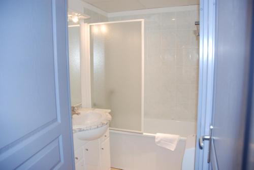 La salle de bains est pourvue d'un lavabo, de toilettes et d'une douche. dans l'établissement UZES APPART HOTEL Résidence Le Mas des Oliviers, à Uzès