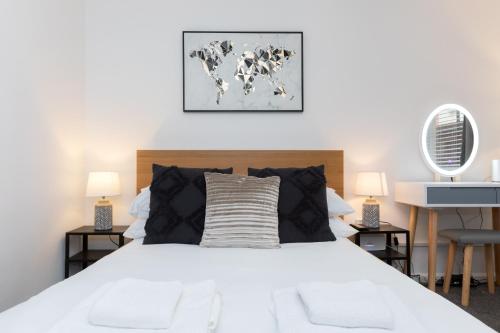 een slaapkamer met een groot wit bed met 2 lampen bij 1 Bed Holiday Apartment,Pets are Welcome in Weymouth