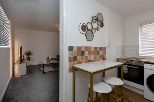 a kitchen with a table and stools in a room at 1 Bed Holiday Apartment,Pets are Welcome in Weymouth