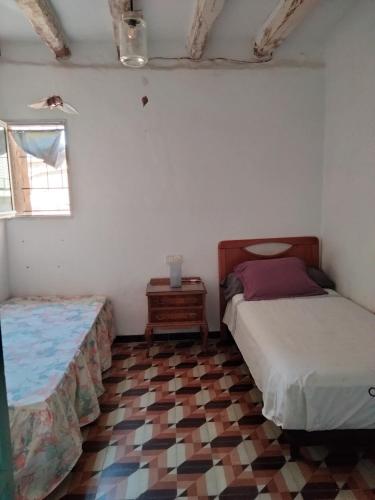 a bedroom with two beds and a tiled floor at Ca l'Anna i l'Antonino in Maldá