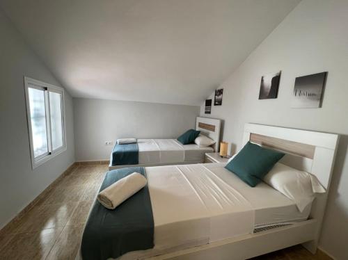 a large bedroom with two beds and a window at Las Palmeras in Benalmádena