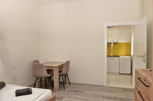 a room with a table and chairs and a kitchen at 4-teen in Jagodina