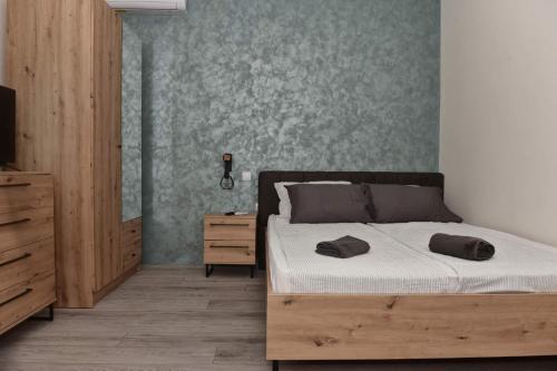 a bedroom with a bed with a wooden bed frame and a dresser at 4-teen in Jagodina