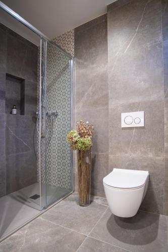 a bathroom with a toilet and a glass shower at Penzion Repanšek in Radomlje