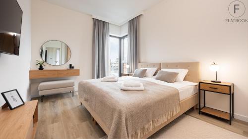 biała sypialnia z dużym łóżkiem i lustrem w obiekcie Flatbook - Yacht Harbor Apartments Sol Marina w mieście Wiślinka