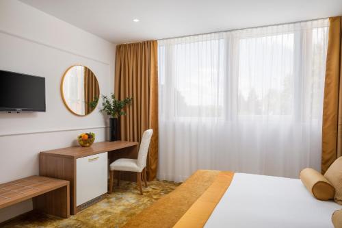 a bedroom with a bed and a desk and a window at Hotel Corner in Split