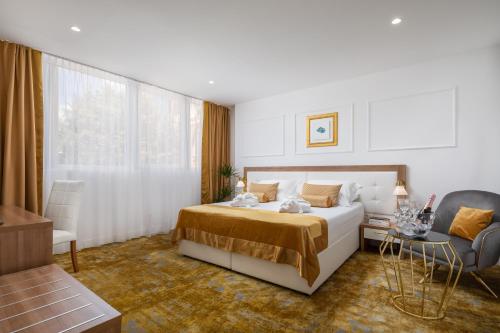 a bedroom with a bed and a couch and a chair at Hotel Corner in Split