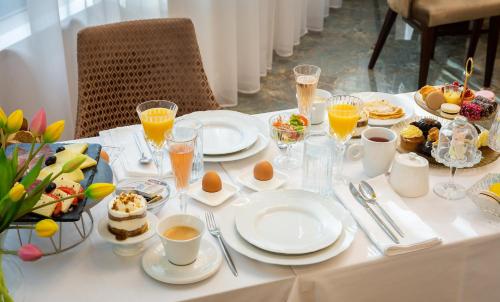 a white table with breakfast foods and drinks on it at Hotel Corner in Split