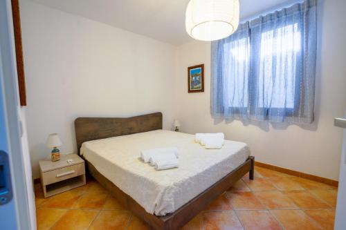 a bedroom with a bed with two towels on it at Casa Coga in Tresnuraghes