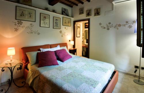 a bedroom with a large bed with purple pillows at Loft in Antico Mulino in Isola d'Arbia