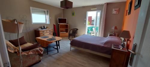 1 dormitorio con 1 cama, 1 mesa y 1 silla en Chambre d'hôte Fleur de Potager en Les Sables-dʼOlonne