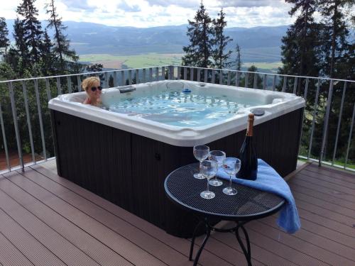 a woman sitting in a bath tub on a deck at Vila Polar in Štrbské Pleso