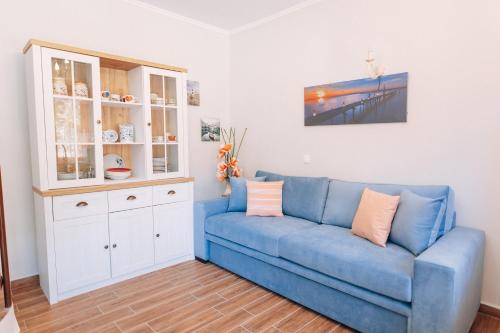 a living room with a blue couch and a cabinet at Edyta's Apartment in Pyrgi