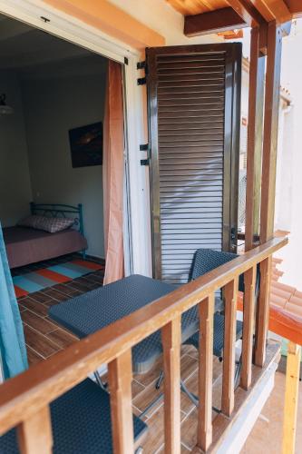 a balcony of a house with chairs and a bed at Edyta's Apartment in Pyrgi