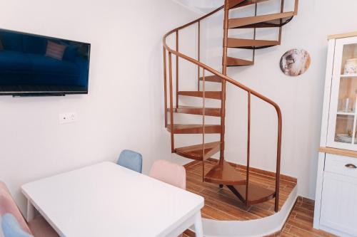 a spiral staircase in a living room with a table at Edyta's Apartment in Pyrgi