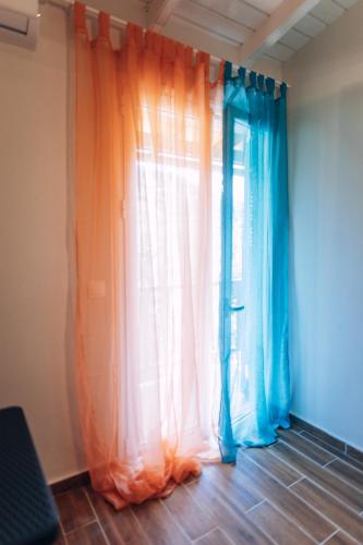an orange and blue curtain in a room at Edyta's Apartment in Pyrgi