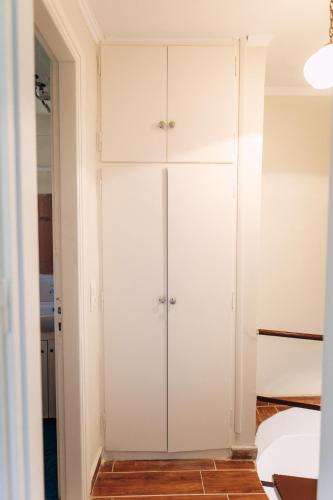 a closet in a bedroom with white cabinets at Edyta's Apartment in Pyrgi