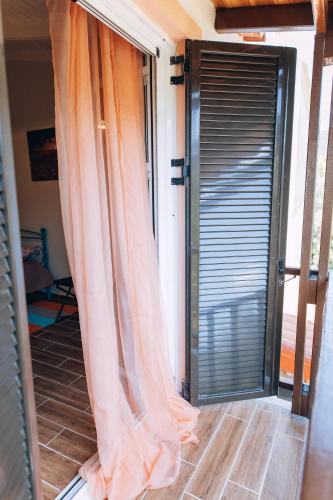 an open door to a balcony with an open curtain at Edyta's Apartment in Pyrgi