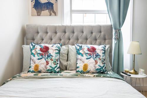 a bedroom with a large bed with floral pillows at Pimlico Hub in London