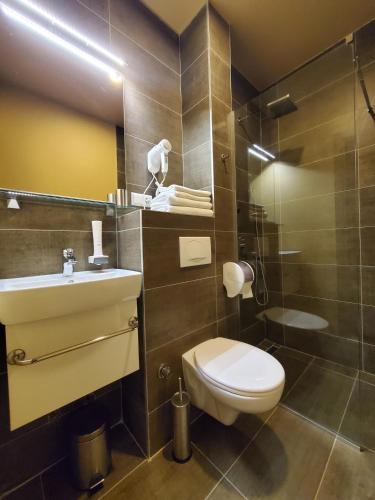a bathroom with a toilet and a sink and a shower at Hotel Argentum in Mostar