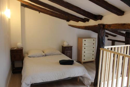 a bedroom with a bed in a room with wooden beams at Gîte proche canal La Conserverie in Buzet-sur-Baïse