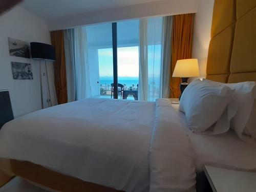 a bedroom with a large white bed with a view of the ocean at Porto Said Hotel & Spa in Port Said