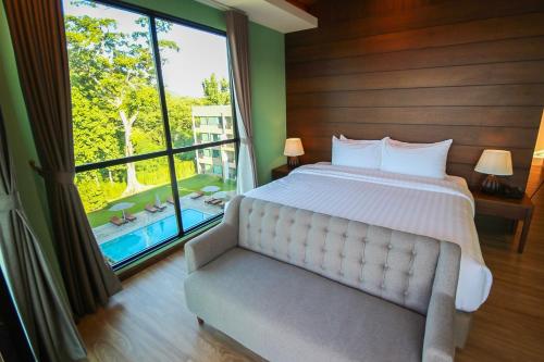 a bedroom with a bed and a large window at River Tree Resort in Chiang Khan