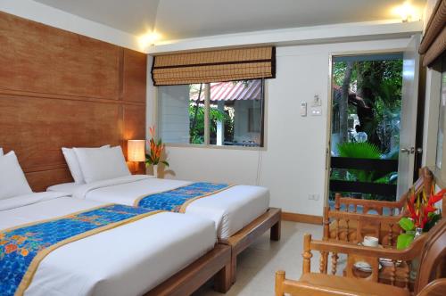 1 Schlafzimmer mit 2 Betten und einem Fenster in der Unterkunft Sunshine Garden Resort in Pattaya North