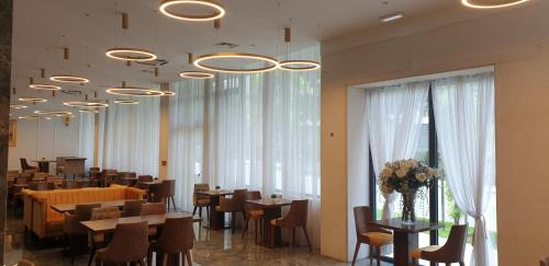a dining room with tables and chairs and windows at Hotel Corner in Split