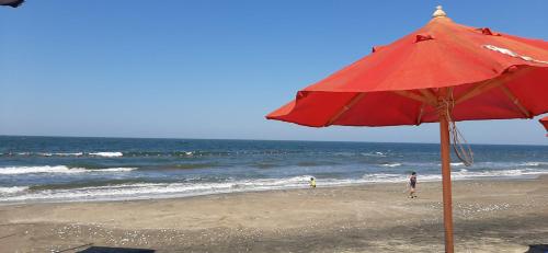 a red umbrella on a beach with the ocean at Porto Said Hotel & Spa in Port Said