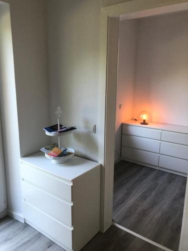 a room with white cabinets and a table with a candle at Ferienwohnung Marli in Marburg an der Lahn