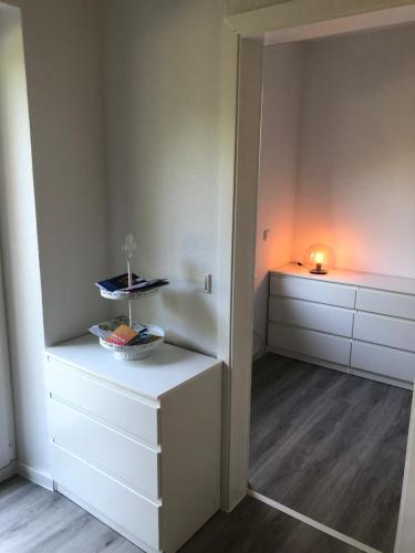 een kamer met witte kasten en een tafel met een kaars bij Ferienwohnung Marli in Marburg an der Lahn