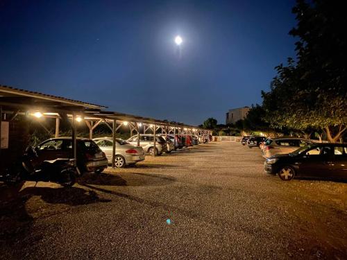 a parking lot with a lot of parked cars at night at Castello Antico Hotel in Gythio