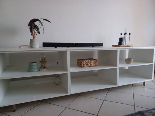 a white shelf with a tv on top of it at The cozy 1 bedroom apartment in Midrand