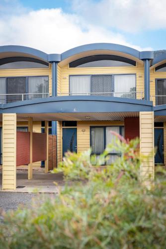 a yellow house with a blue roof at Halls Gap Escape Townhouses in Halls Gap